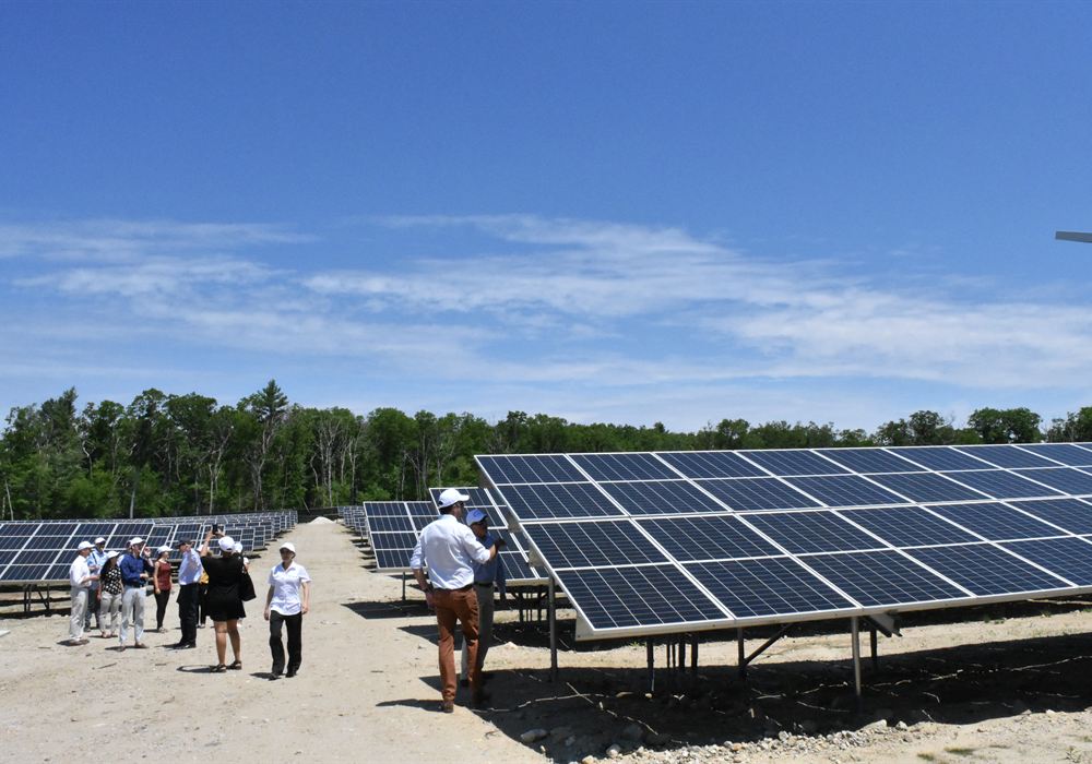 Technicians walking a ground-mount array at Hartford Pike during a site inspection