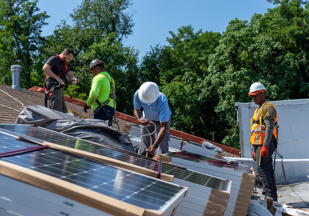 Crew performing repair work on a rooftop solar installation