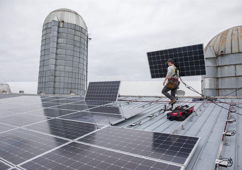 Technicians installing solar modules on a metal roof in Vermont